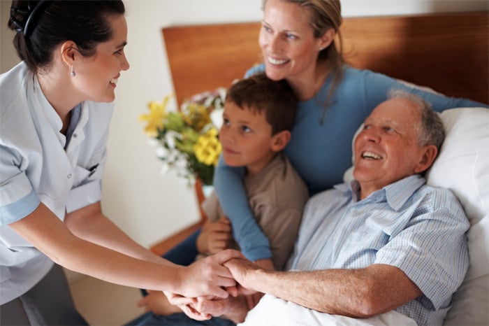 Family and care team surrounding hospice patient